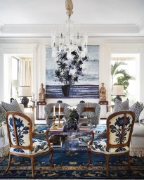 Elegant living room interior with patterned armchairs, large floral art piece, and ornate crystal chandelier by Björn Wallander