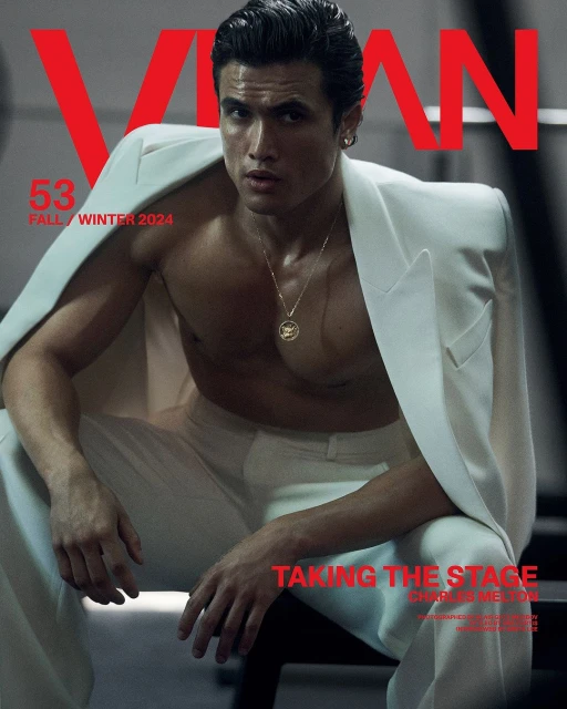 Magazine cover featuring a male fashion model in a white suit jacket and pants, posing with a serious expression indoors.