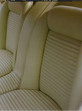 Beige-colored automotive interior featuring ribbed texture seat with vertical lines and a smooth headrest, showcasing comfort and design.