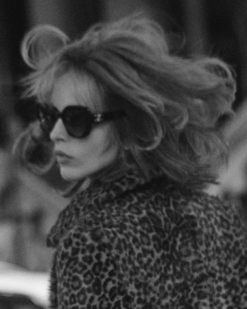 Monochrome portrait of a woman with voluminous hair wearing sunglasses and a leopard print coat by Blair Getz Mezibov