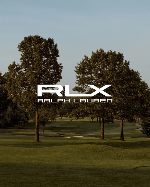 RLX Ralph Lauren logo displayed over a green golf course surrounded by trees on a sunny day with a clear blue sky.