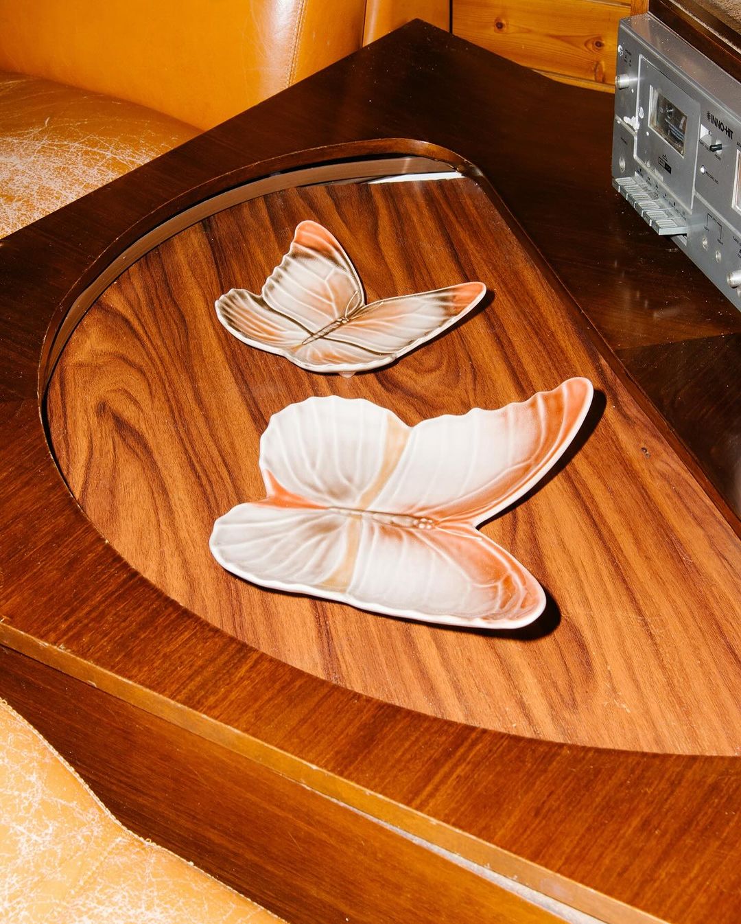 Butterfly-shaped decorative plates on a wood table, enhanced by warm lighting and retro-style decor.