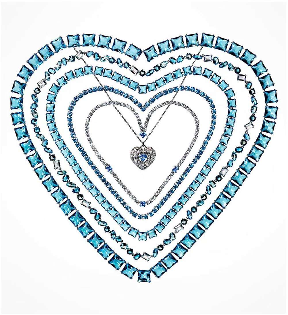 Necklaces with blue and white gemstones arranged in a heart shape against a white background, creating a visually appealing composition.