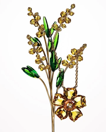 Close-up studio shot of a decorative art sculpture featuring crystal and glass elements in the shape of a flower and a blooming branch.
