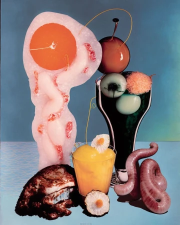 Still life composition features a surreal arrangement of food-like objects in vibrant colors on a light blue background.