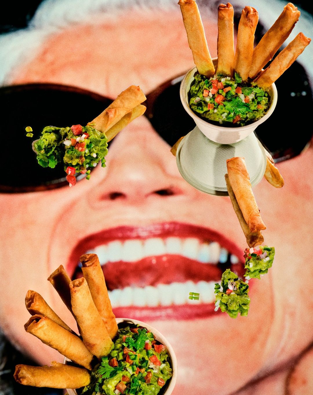 Overhead shot of taquitos and guacamole arranged in a surreal pattern over an image of a woman's face and teeth.