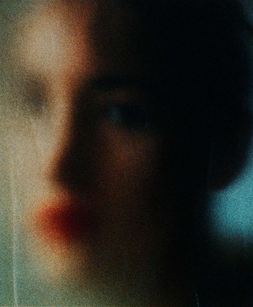 Portrait of an androgynous person with soft skin, blurred details, and muted coloring in a close-up, side view with blue and peach tones.