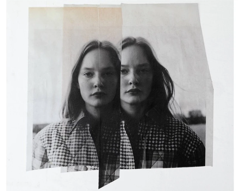 Monochrome art print features two women's faces on vertically-aligned paper. The women have long hair and are wearing checkered tops.