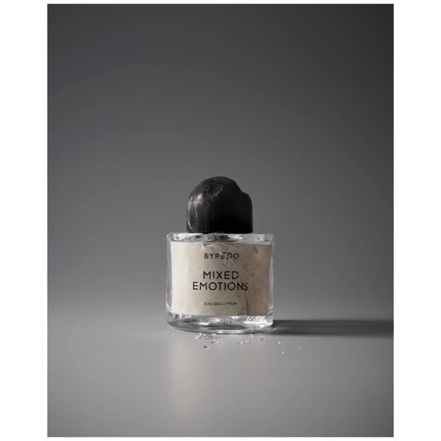 Studio shot of Byredo Mixed Emotions perfume bottle with a black cap on a grey background, beauty and cosmetics product photography.