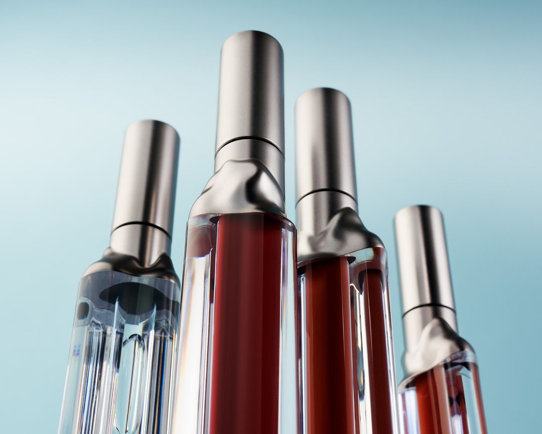 Four clear vials stand in a row against a light blue backdrop, filled with differing amounts of red liquid and topped with silver caps.