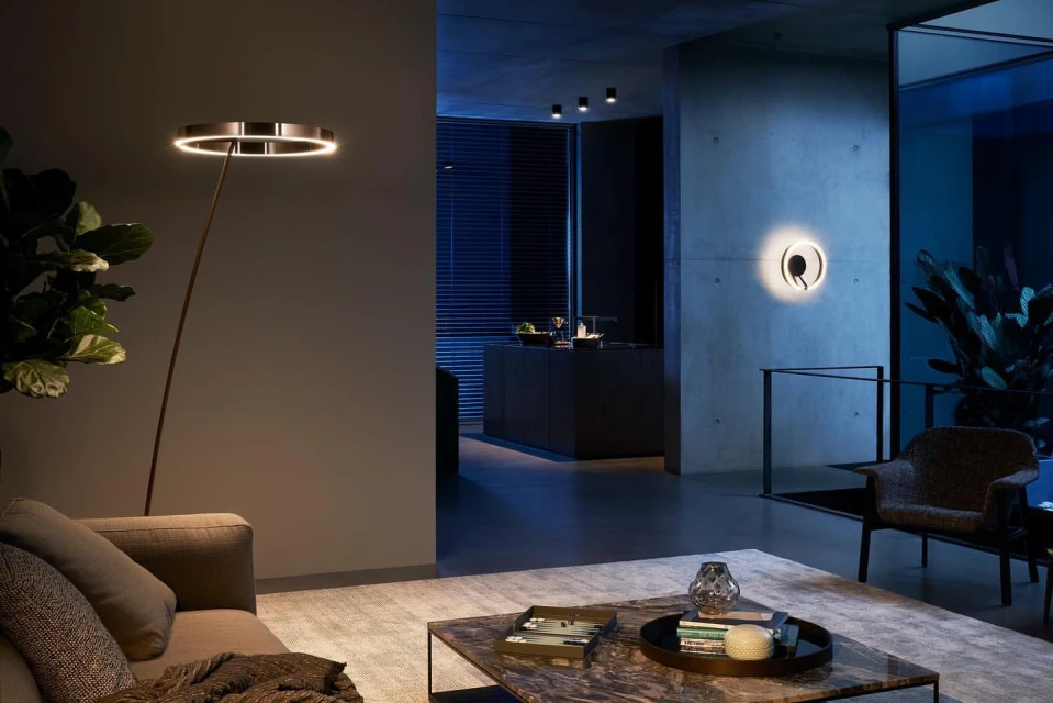 Interior design featuring modern living room with gray sofa, marble coffee table, decorative objects, and floor lamp with circular LED light.
