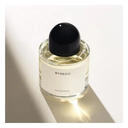 Byredo eau de parfum glass bottle with black spherical cap on light surface with diagonal shadow by Bohman+sjostrand