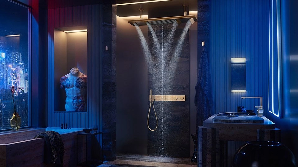 Modern luxury bathroom interior featuring a rainfall showerhead spraying water and gold fixtures against a dark stone wall