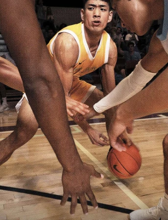 A dynamic medium shot of a basketball game featuring a determined Asian adult male athlete dribbling, framed by teammates and opponents.