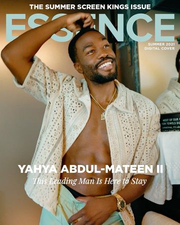 Essence cover featuring Yahya Abdul-Mateen II in a light-colored, open, patterned shirt and light green pants, accessorized with gold jewelry.