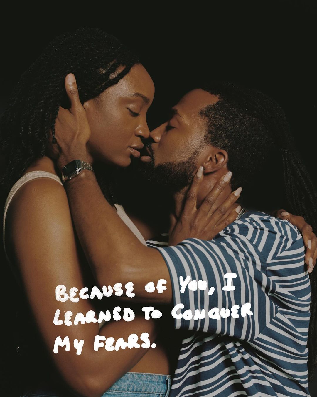 A close-up studio portrait captures an African-American couple embracing tenderly against a dark background with an inspirational text overlay.