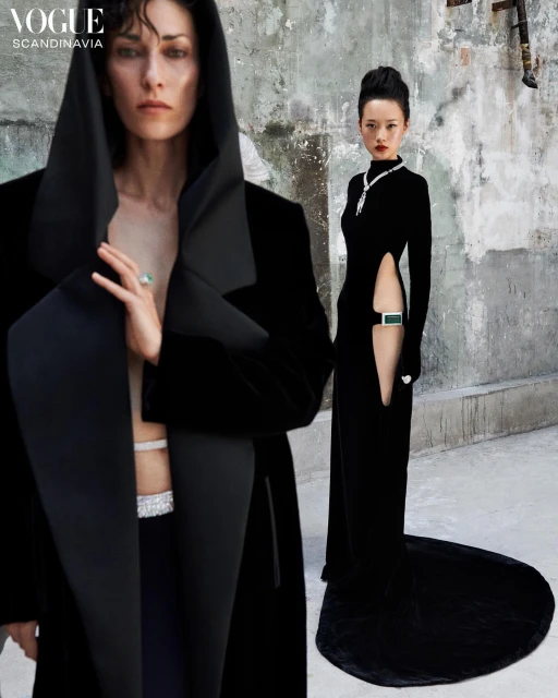 Two women in elegant black dresses and jewelry pose against a textured wall in a fashion editorial for Vogue Scandinavia, full shot.