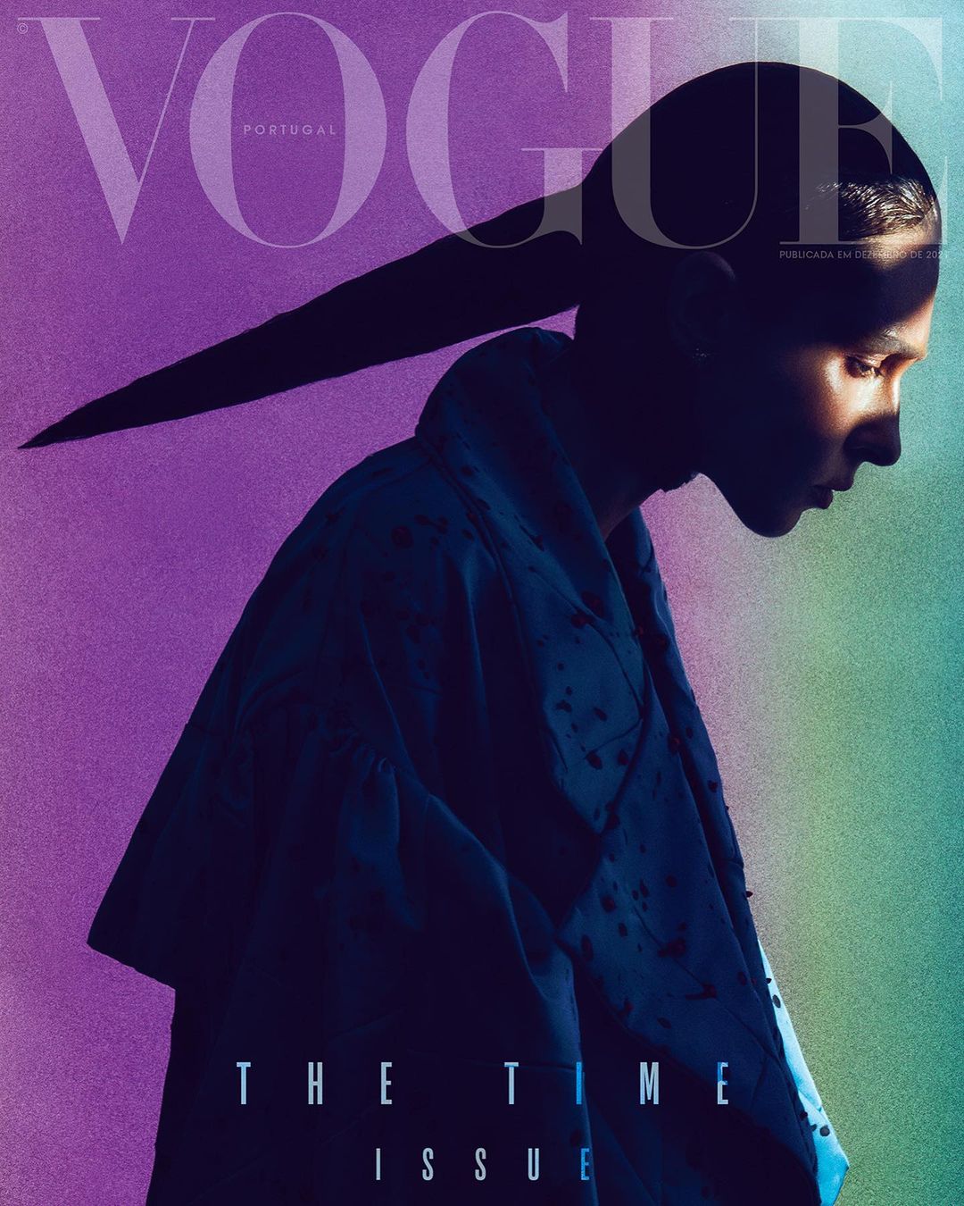 Vogue Portugal magazine cover featuring a model in profile with a long ponytail, shot in a photo studio with colored gel lighting.