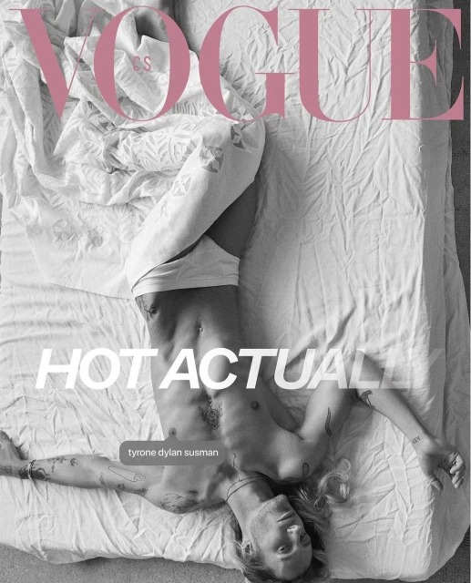 Shirtless man, Tyrone Dylan Susman, poses on a white bed with tattoos visible, featured in Vogue magazine cover with pink logo.