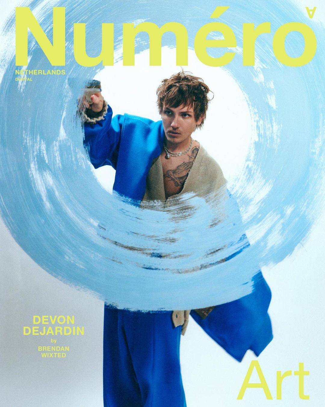 Numero Netherlands magazine cover featuring a male model in blue outfit partially obscured by brushstroke on a white background.