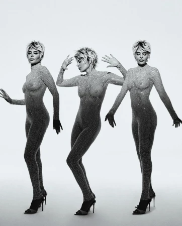 Three adult women posing in sheer catsuits and high heels on a white background, showcasing a mirrored, monochromatic fashion shot.