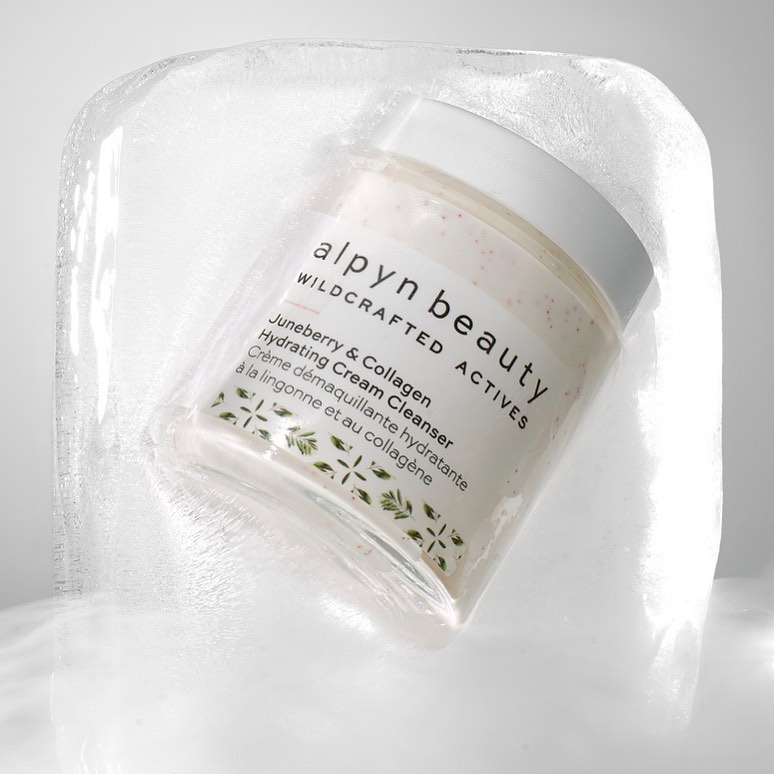 Alpyn Beauty cleanser encased in a block of ice, close-up product shot against a light grey background. Skincare and beauty concept.
