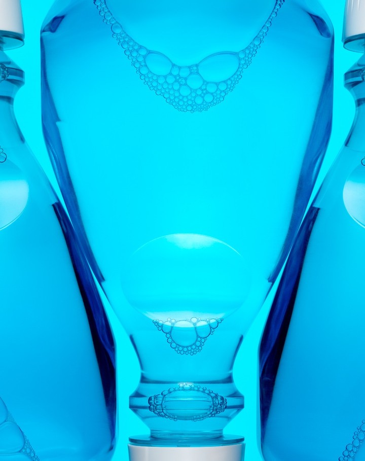 Still life of three blue mouthwash bottles against a vibrant blue background, creating a fresh, clean, and visually striking composition.