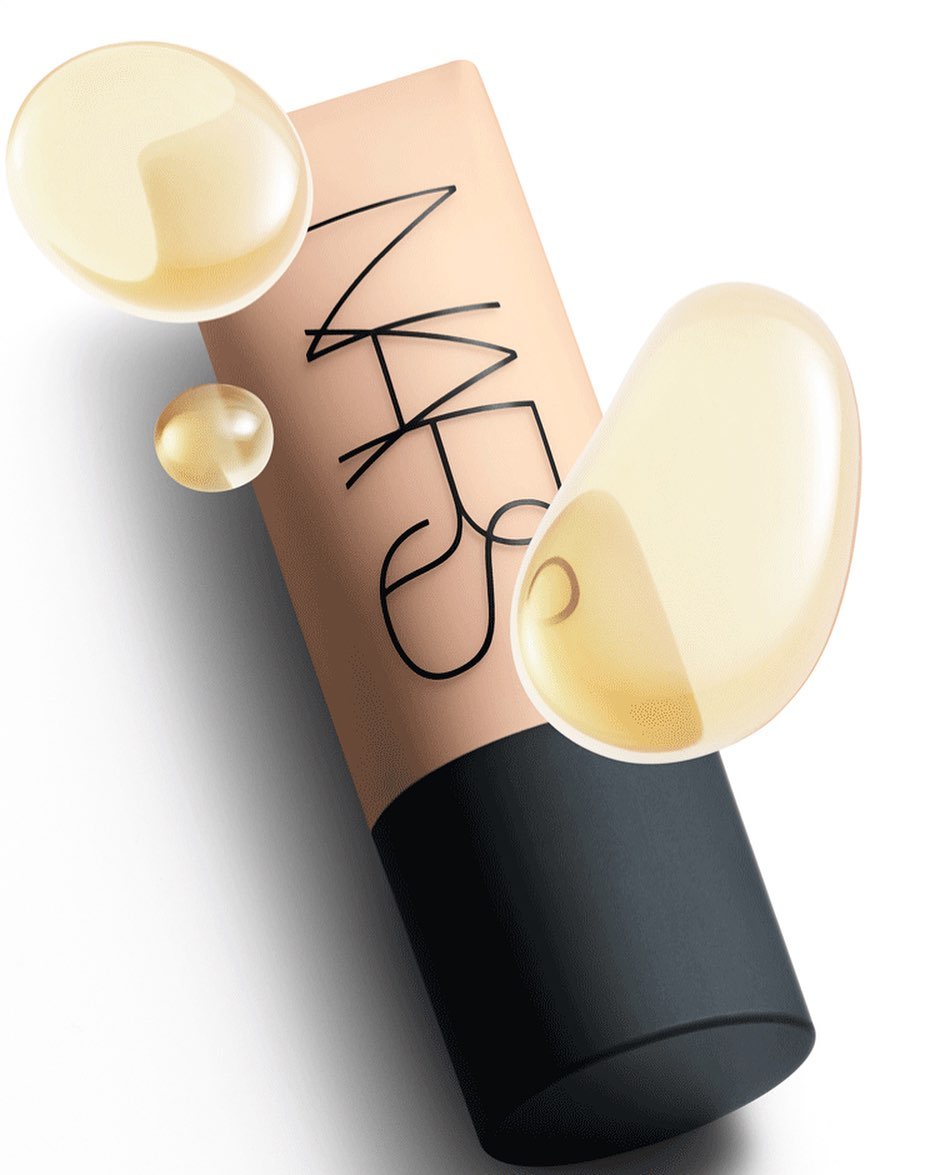 NARS foundation tube with three drops of oil, set against a white background, showcasing cosmetic and beauty product presentation.