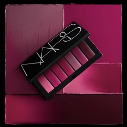 An open NARS makeup palette displaying six pink and purple shades set against a dark textured background.