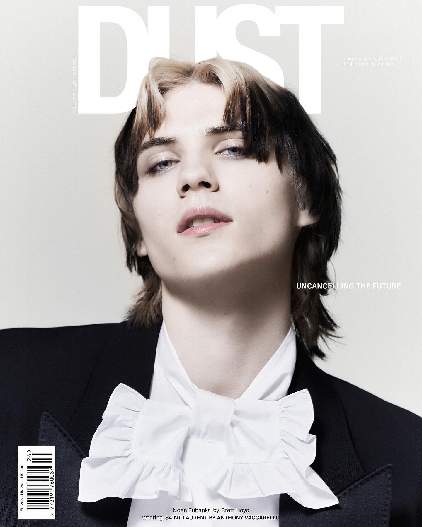 Magazine cover featuring a young adult with light skin, styled black and blonde hair, wearing a black blazer and white ruffled shirt.