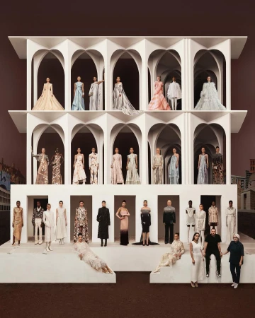 Fashion show featuring diverse models wearing a variety of elegant gowns and dresses, staged on a tiered white platform with arches.