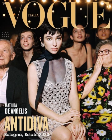 Vogue Italia cover featuring Matilde De Angelis in a silver dress, surrounded by a diverse group of people in a lit setting.
