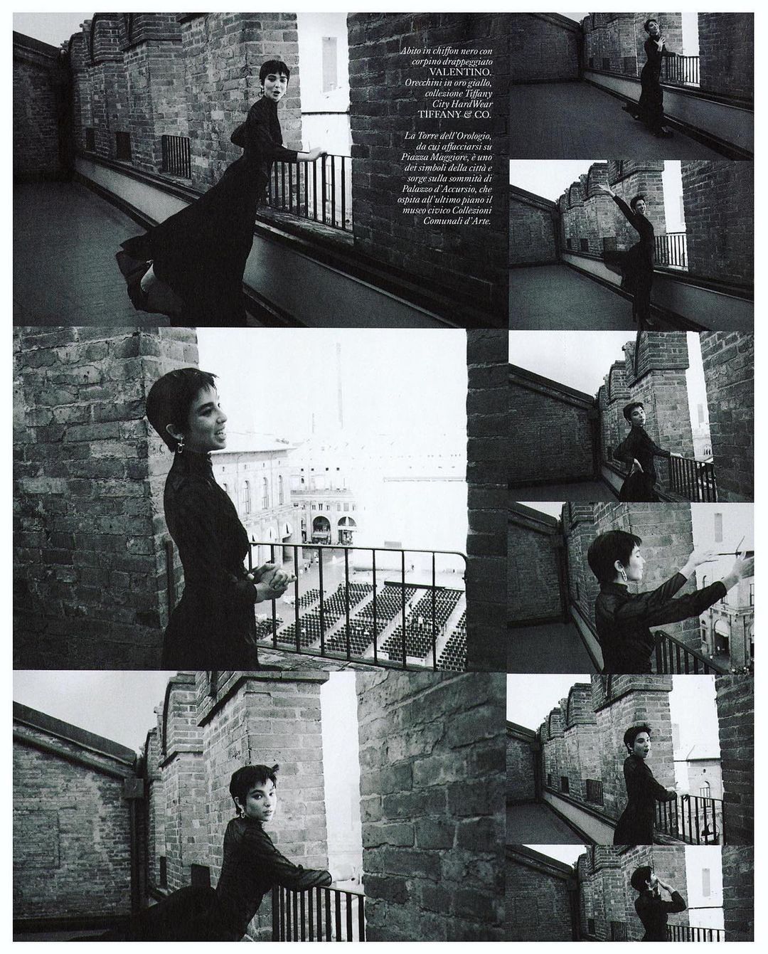 Woman in elegant dress poses on castle turret overlooking city. Editorial fashion shot with historical architecture and monochromatic color.