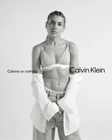 Black and white portrait of a woman wearing a bralette and unbuttoned white shirt, photographed by Brianna Capozzi.