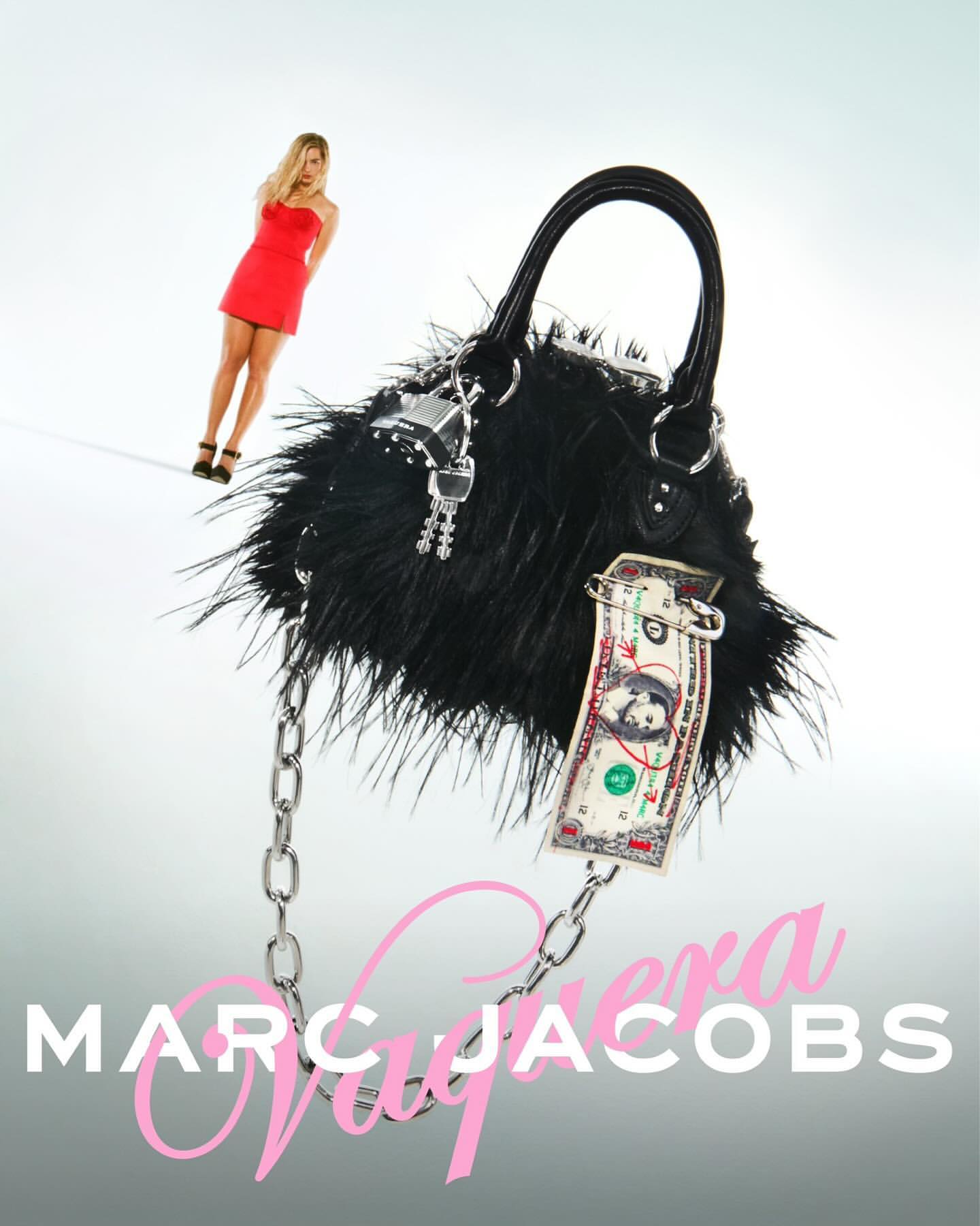 Blonde woman in a red dress next to a fuzzy black handbag with a chain strap against a gradient white studio background.