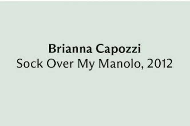 Image features the text 'Brianna Capozzi, Sock Over My Manolo, 2012' in a simple sans-serif font against a pale grey background.