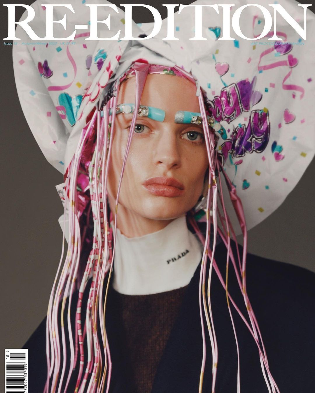 Fashion magazine cover featuring a model wearing a white headscarf, strands of pink hair extensions, Prada top, and light turquoise makeup.