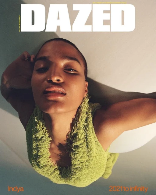 Dazed cover featuring Indya Moore in a light-green fringed tank top, shot from a low angle against a light-grey and white backdrop.