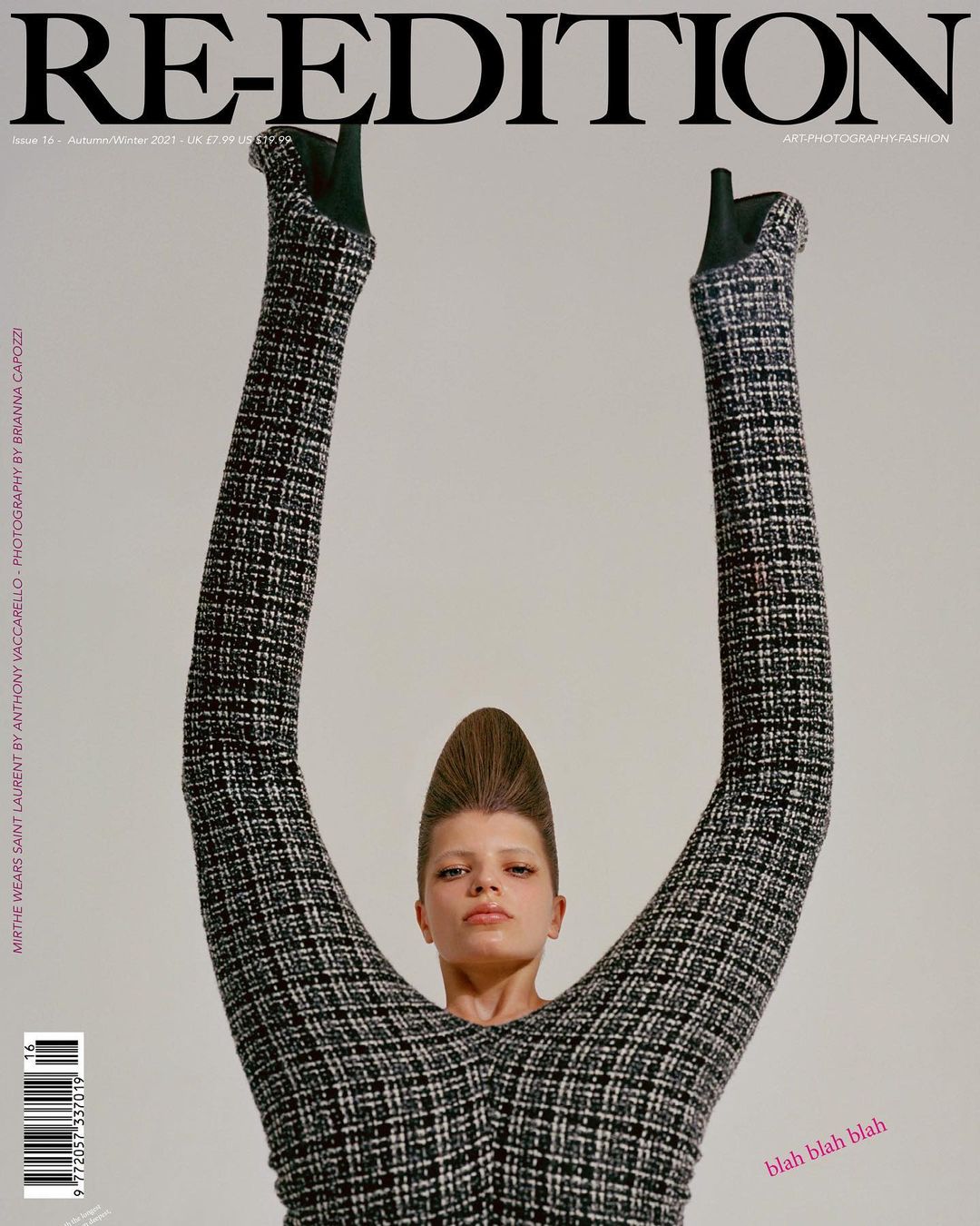 Magazine cover featuring a model in a tweed jumpsuit with legs raised overhead, showcasing unique fashion and editorial photography.