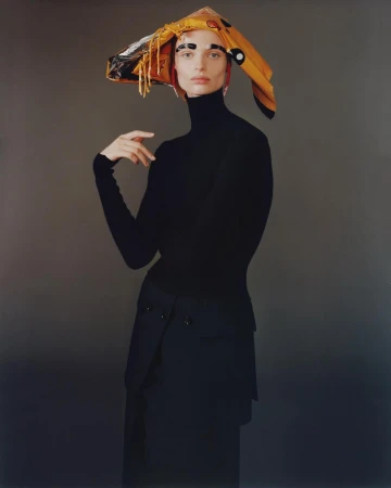 Model wearing a black turtleneck and an asymmetric yellow patterned headscarf photographed by Brianna Capozzi.