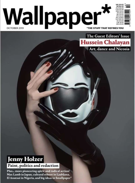 Wallpaper* magazine cover featuring a person in black gloves holding a black and white mask with the magazine logo and text.