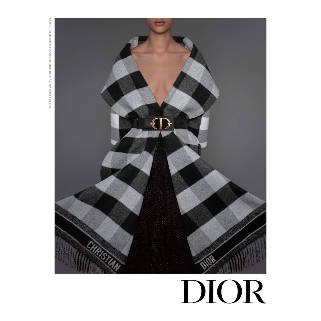 Model wearing a black and white plaid fringed coat belted with a large gold CD logo buckle by photographer Brigitte Niedermair