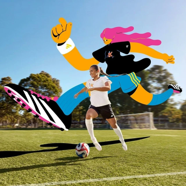 Woman soccer player dribbling ball on green field with Adidas shoe artwork, set against a clear blue sky, in a vibrant sports image.