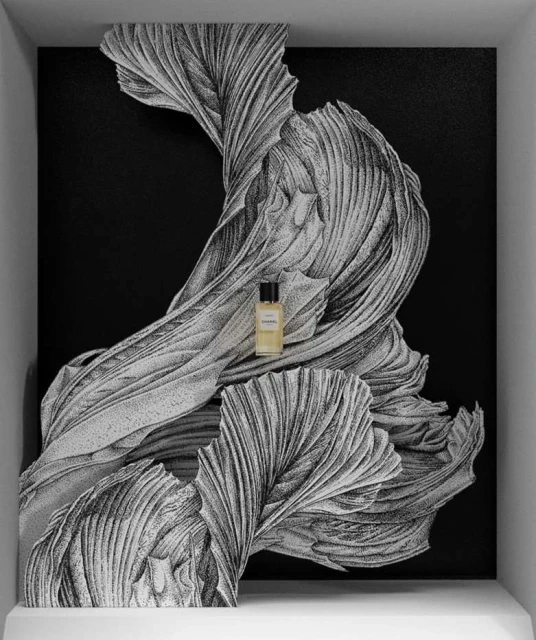 Close-up product shot of a perfume bottle with black lid. The bottle is placed in front of an abstract swirling black and white pattern.