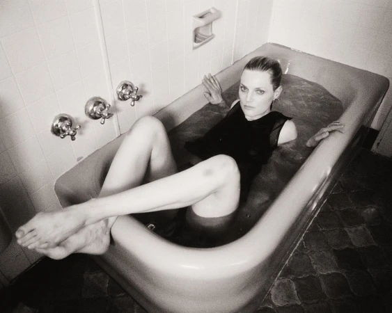 Black and white portrait of a woman in a bathtub wearing a dark top, photographed from a high angle by Bryan Liston.