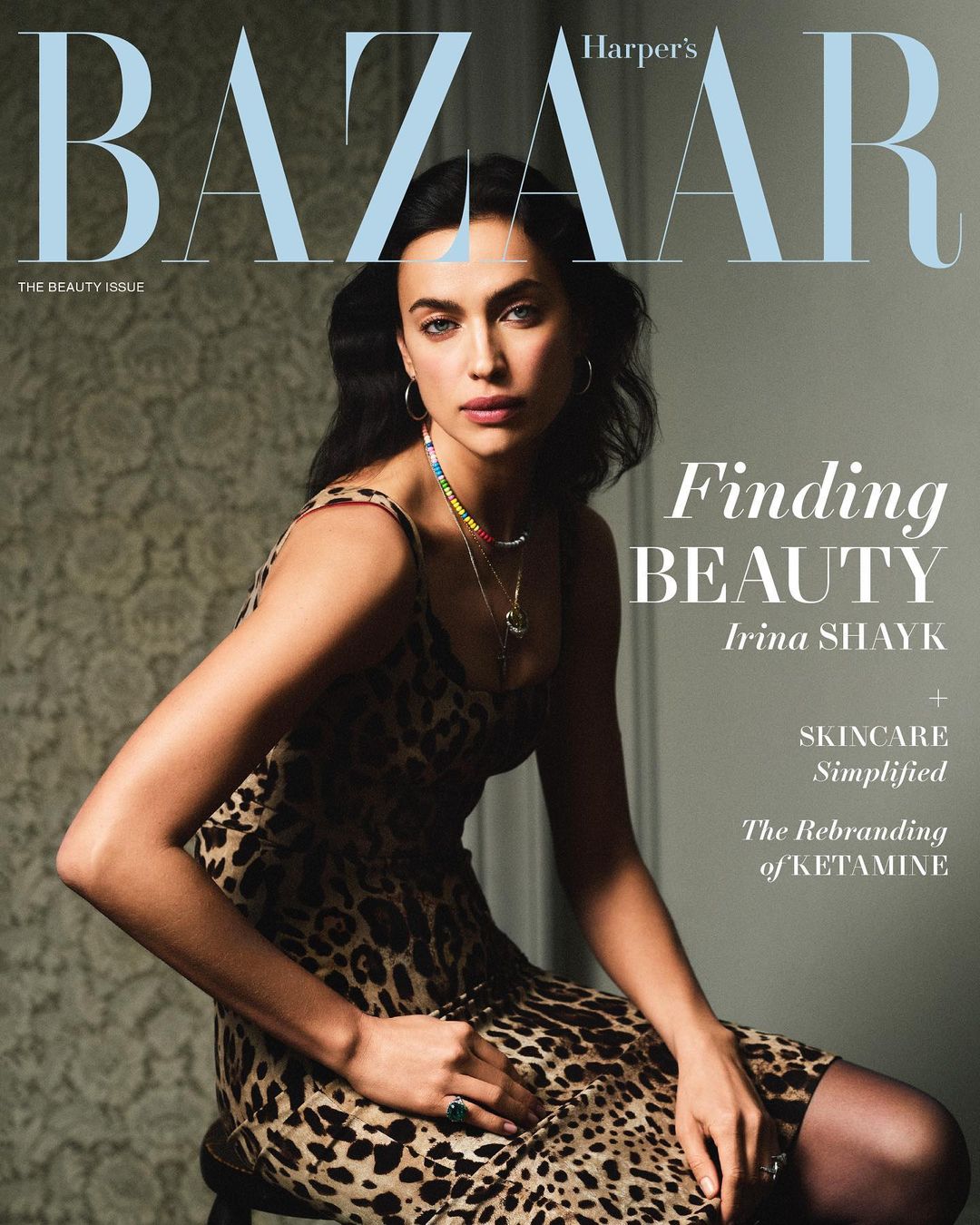 Magazine cover featuring Irina Shayk in an animal-print dress, seated, with Bazaar masthead and article titles in sans-serif typography.