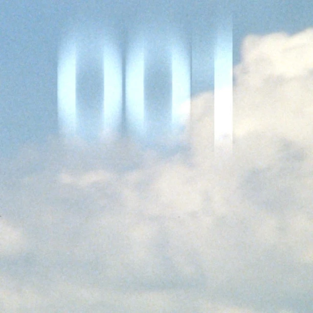 Abstract shot of white and pale blue clouds, featuring a blurred column effect overlaying the sky.