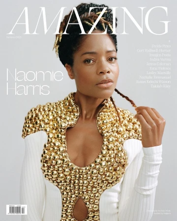 Magazine cover featuring Naomi Harris, wearing a white dress with gold embellishments, in front of a light grey background with text.