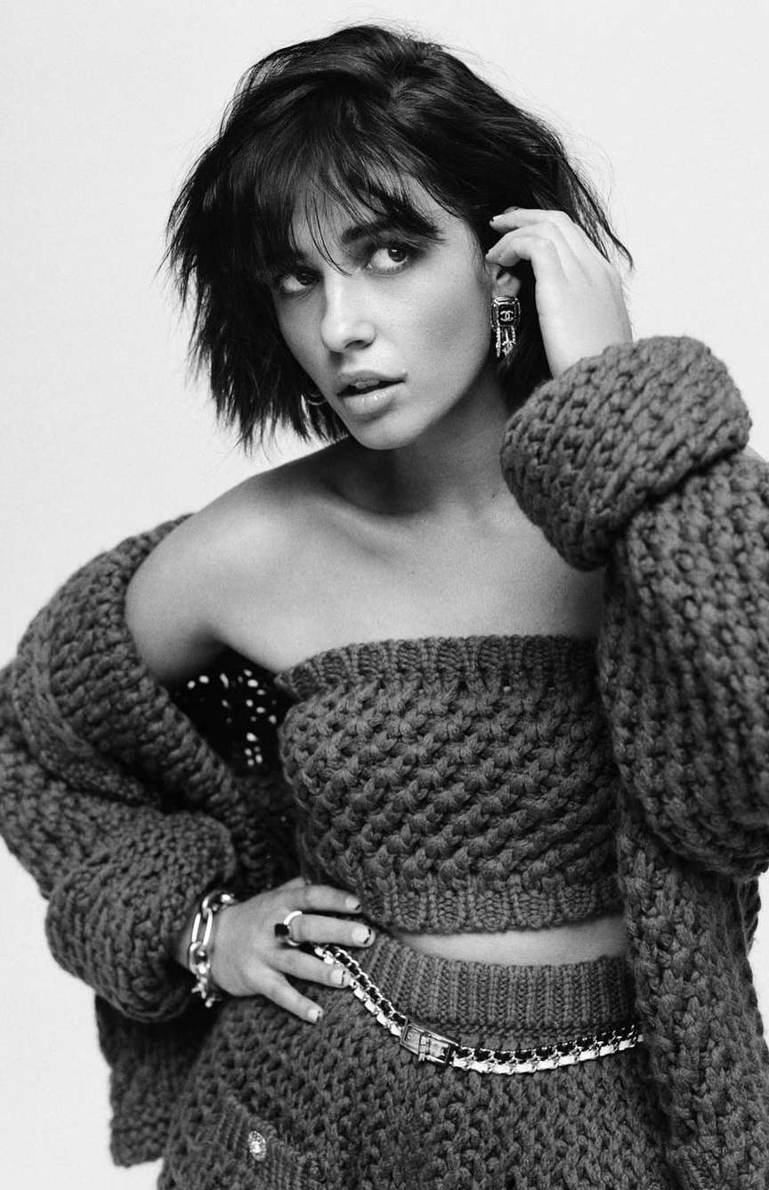 Black and white portrait of a woman with dark hair wearing a chunky knit strapless top and cardigan, photographed by Buzz White.