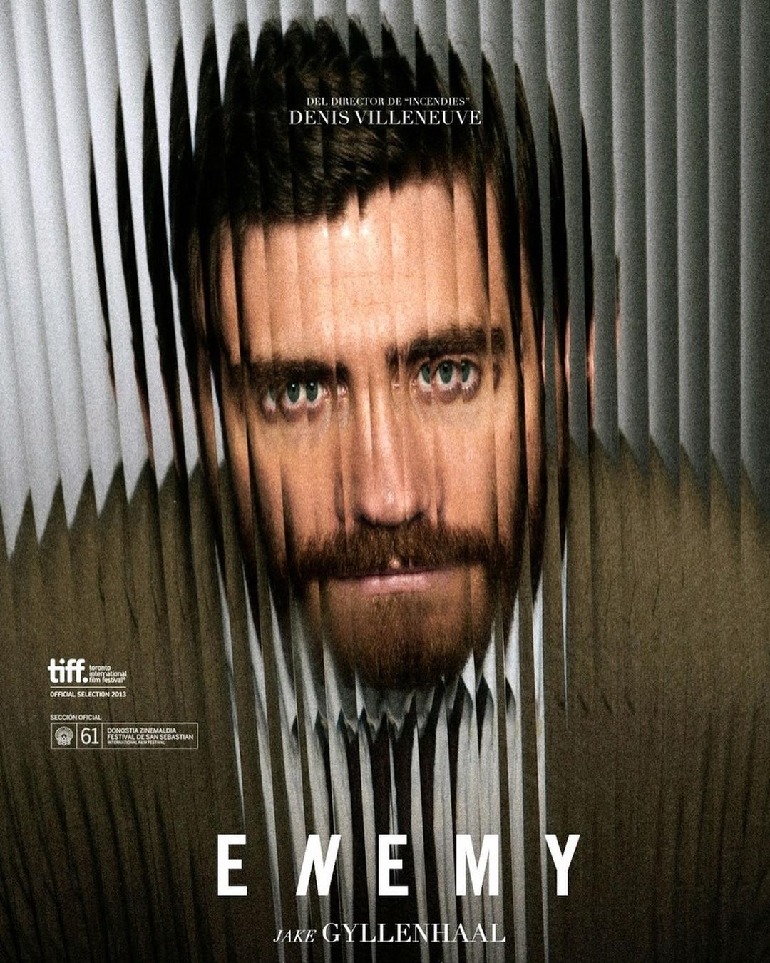Movie poster for 'Enemy' features Jake Gyllenhaal's face distorted by vertical lines, creating an eerie, fragmented effect. 